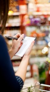 A woman cross off a grocery list in the store
