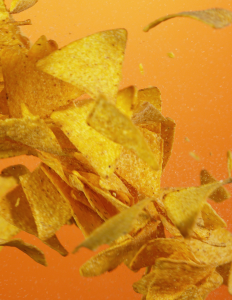 Corn chips scattered against an orange background